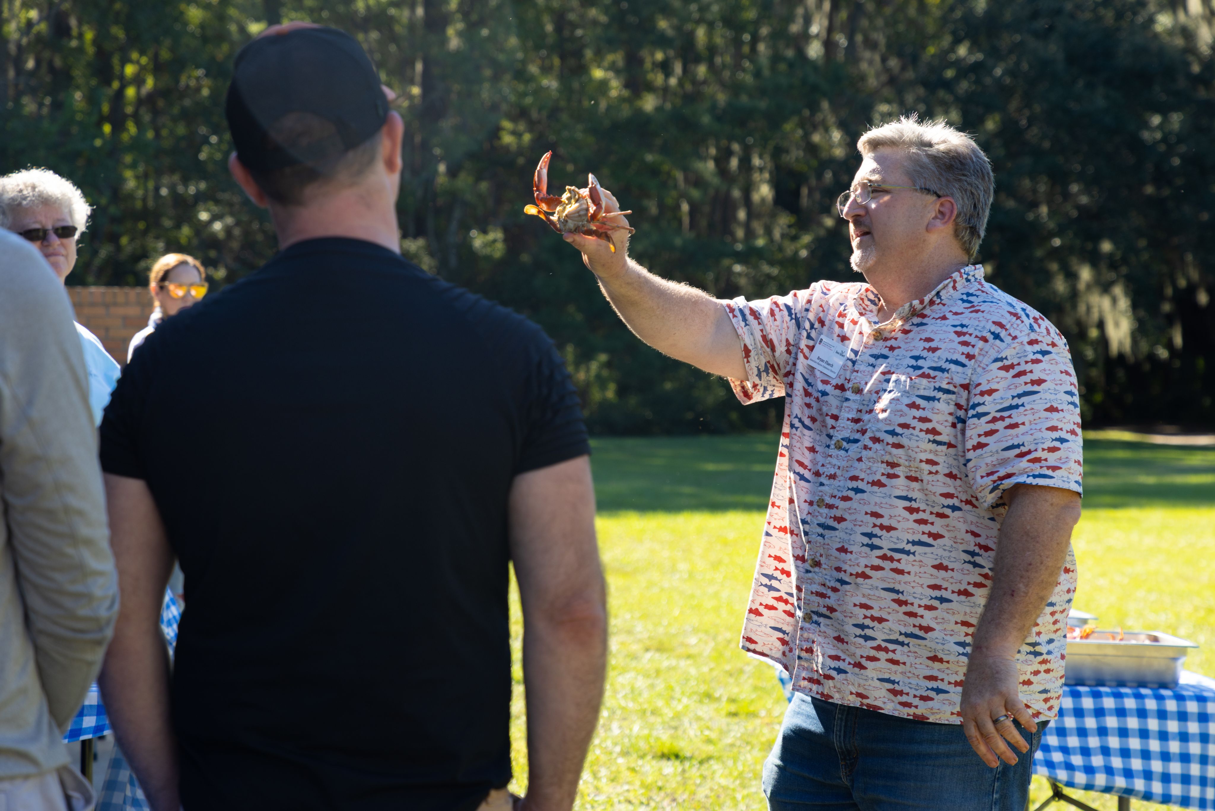 Associate Director of Extension Bryan Fluech, displaying a blue crab for participants of the Taste of the Coast Public Program in 2025.